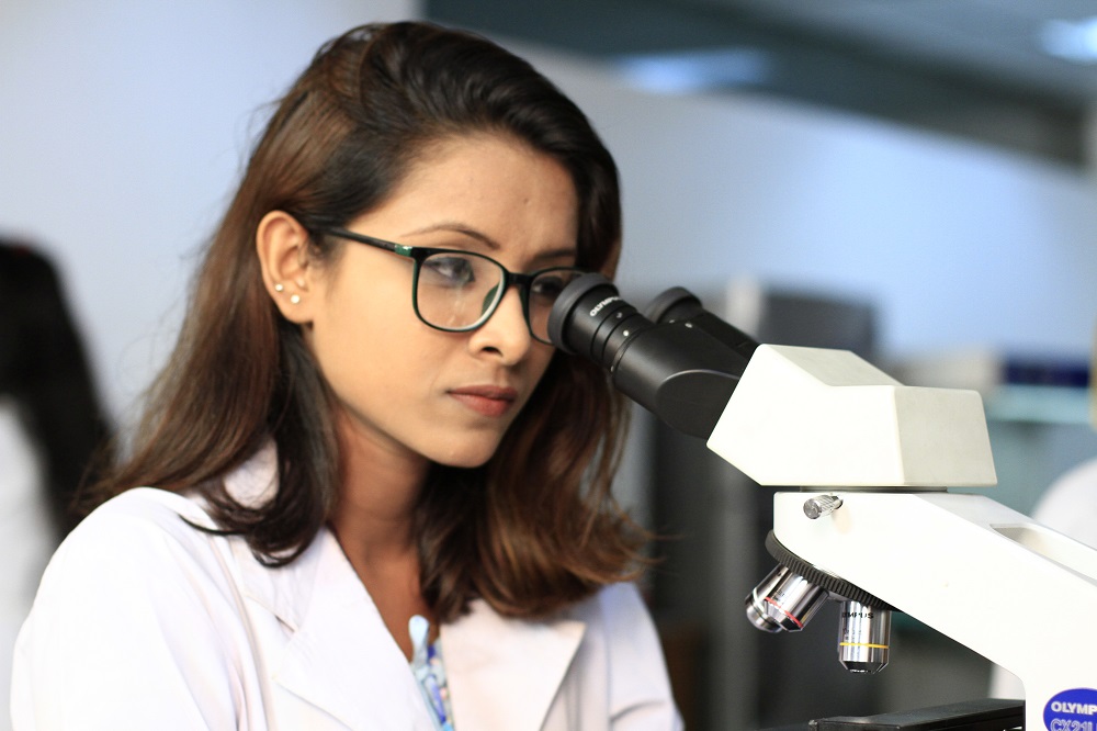 Student examining sample under Microscope.JPG